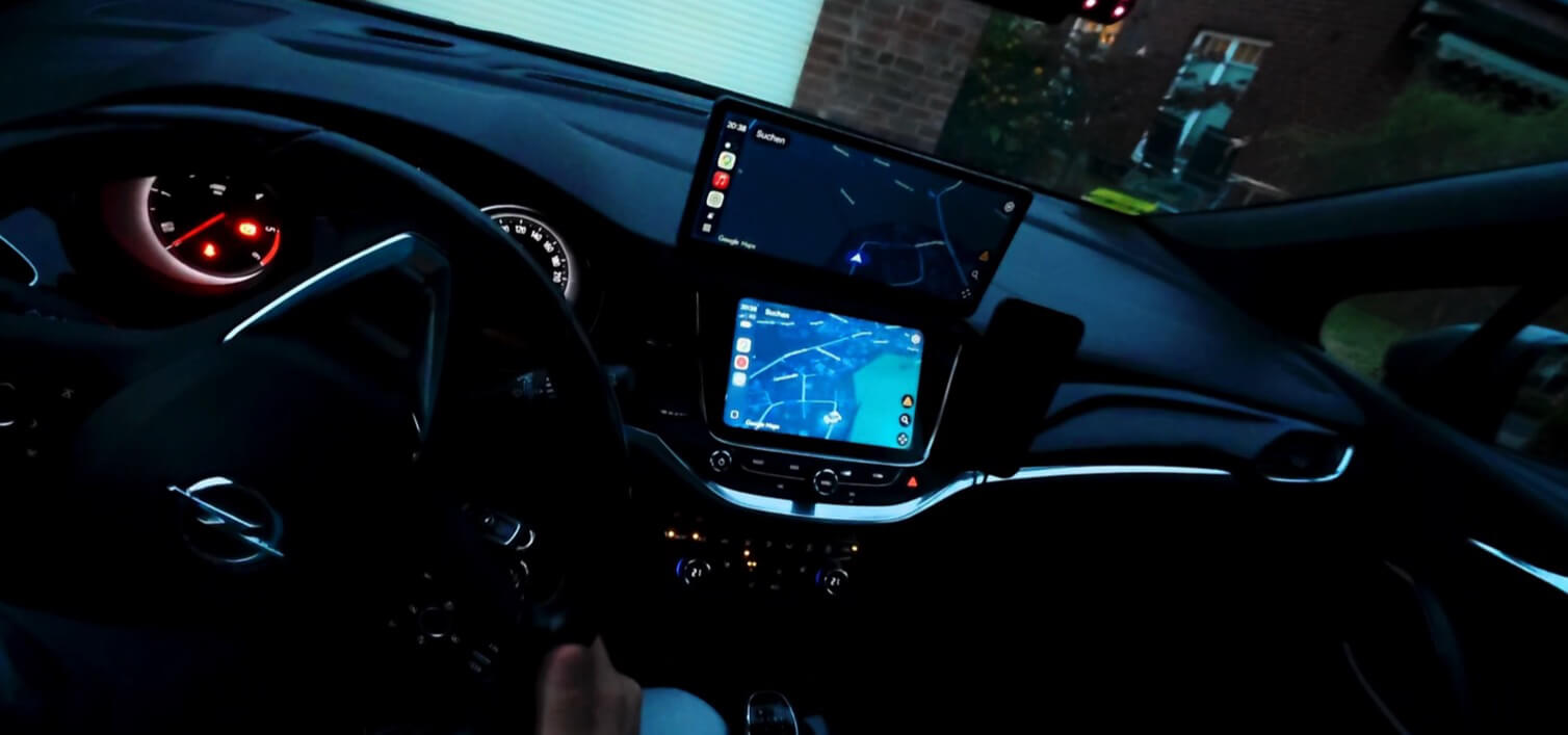 Abgedunkeltes CarpodGo T4 Plus über dem helleren Werksdisplay des Opel Astra K bei Nacht
