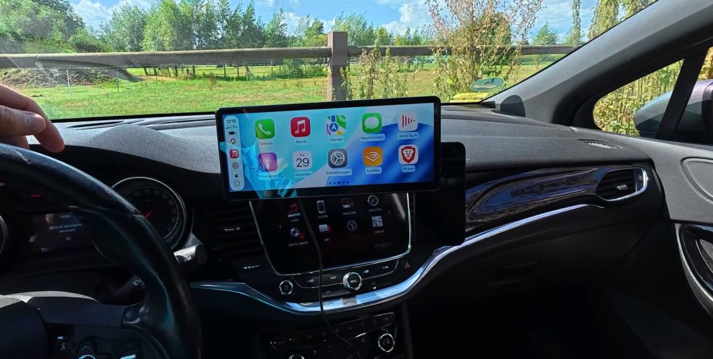 CarpodGo T4 Plus mit gut erkennbarer CarPlay-Oberfläche bei Sonnenschein im Opel Astra K
